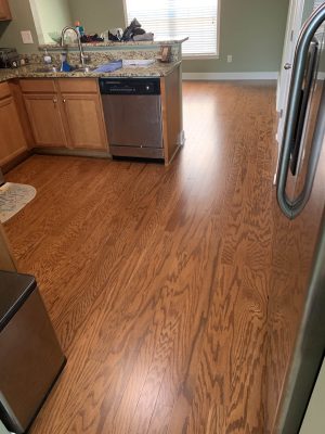 medium brown, wood floor in kitchen with green walls & white trim