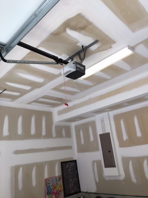 newly restored walls & ceiling of garage showing white tape & dry wall mud