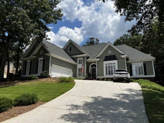 dark gray & black house sitting up on a hill - a before picture